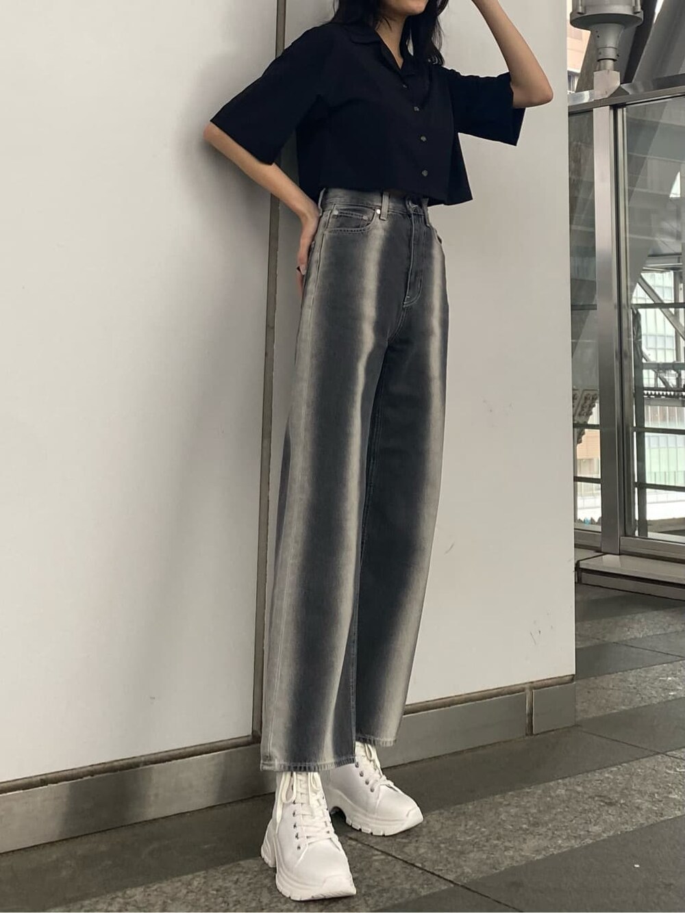 ブラック系のデニムパンツ、ブラック系のシャツ/ブラウス、ホワイト系のスニーカーを着用したレディースの春コーディネートの3枚目の写真