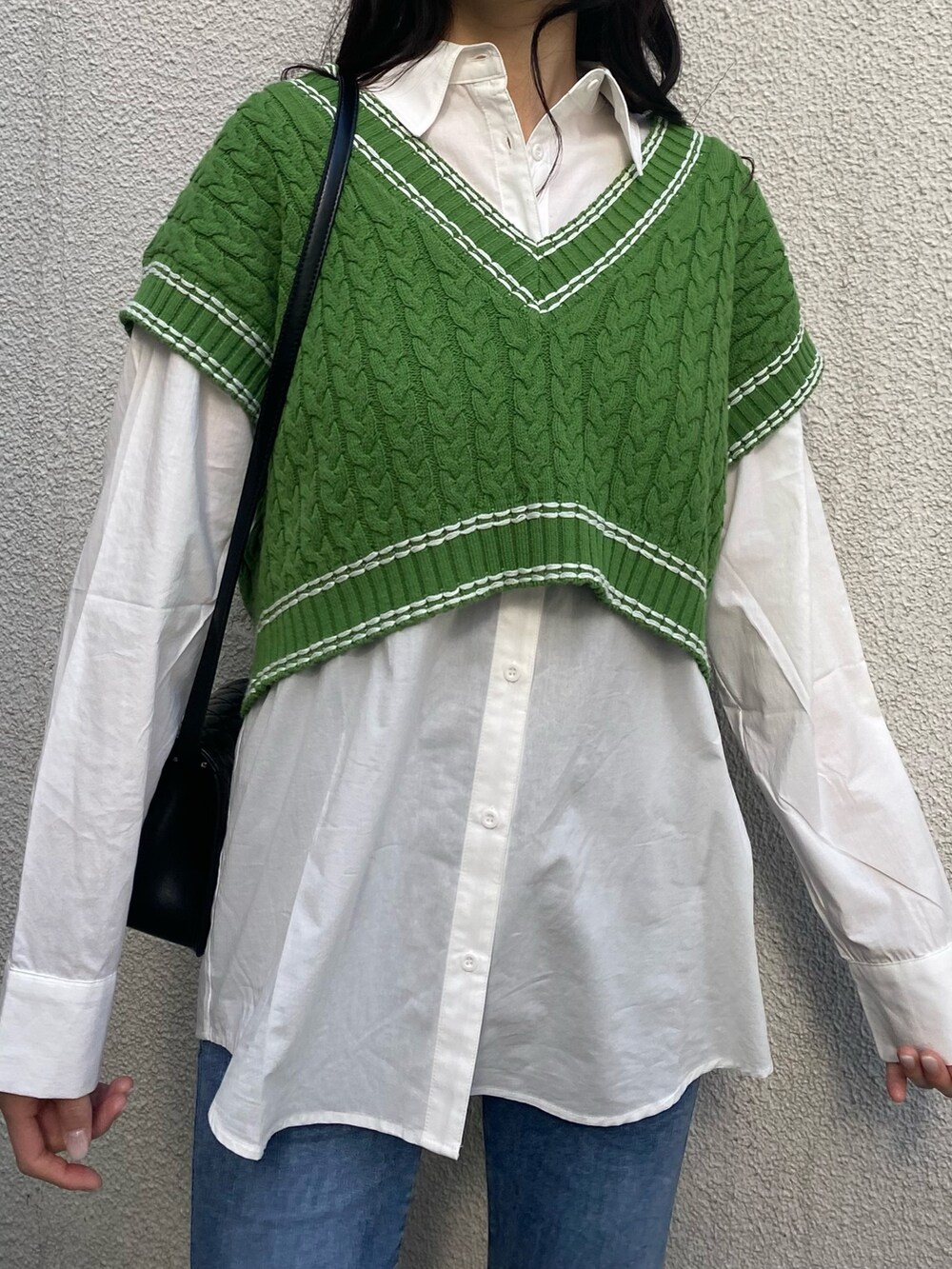 グリーン系のベスト、ホワイト系のシャツ/ブラウス、ブラック系のショルダーバッグを着用したレディースの冬コーディネートの6枚目の写真