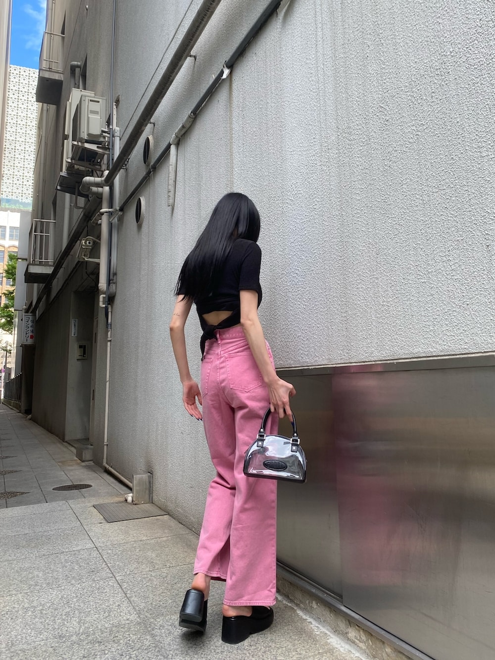 ピンク系のデニムパンツ、ブラック系のTシャツ/カットソー、その他のハンドバッグを着用したレディースの春コーディネートの3枚目の写真