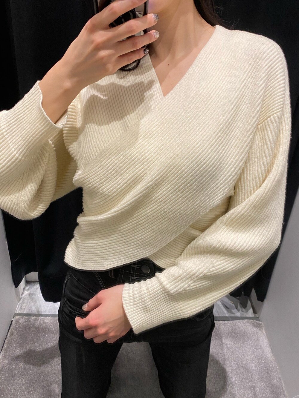 ホワイト系のニット/セーター、ブラック系のデニムパンツを着用したレディースの冬コーディネートの4枚目の写真