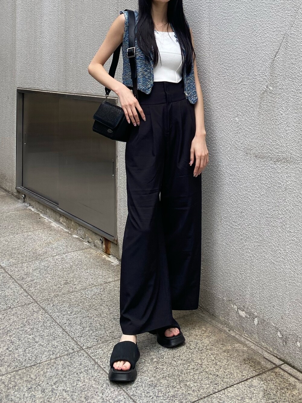 ホワイト系のニット/セーター、ブラック系のその他パンツ、ブラック系のショルダーバッグを着用したレディースの夏コーディネートの5枚目の写真