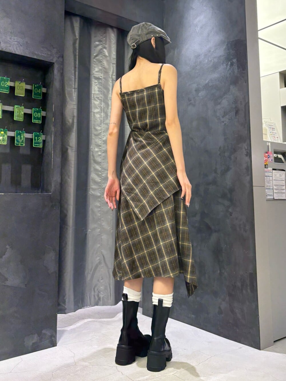 グリーン系のワンピース、ブラック系のブーツ、グレー系のハンチング/ベレー帽を着用したレディースの夏コーディネートの5枚目の写真