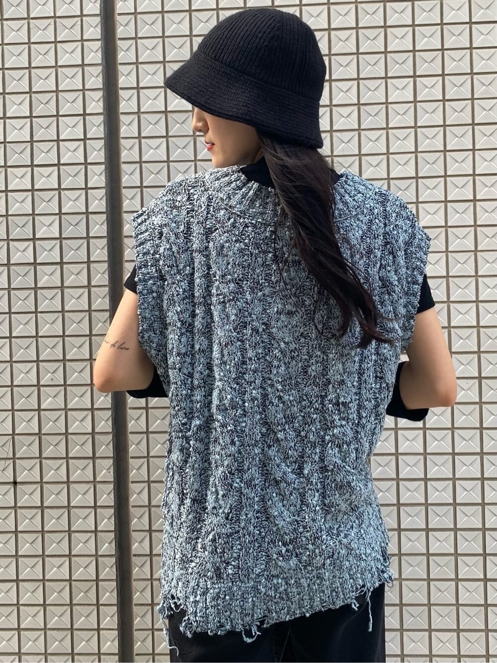 ブラック系のデニムパンツ、ブルー系のベスト、ブラック系のスリッポンを着用したレディースの夏コーディネートの6枚目の写真