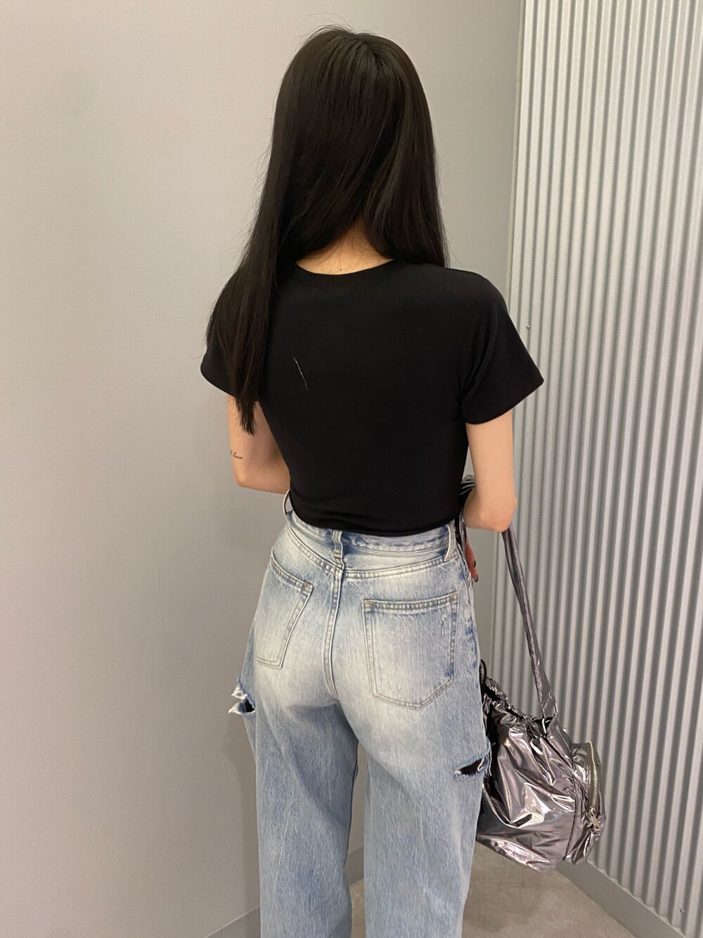 ブラック系のTシャツ/カットソー、ブラック系のサンダル、ブルー系のデニムパンツを着用したレディースの夏コーディネートの7枚目の写真