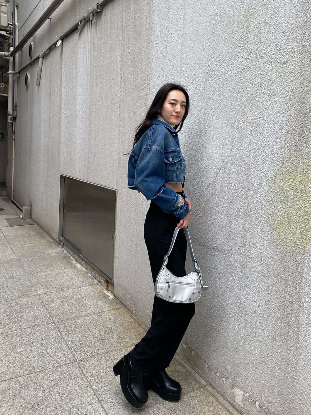 ブラック系のその他パンツ、ホワイト系のニット/セーター、ブルー系のデニムジャケットを着用したレディースの春コーディネートの2枚目の写真