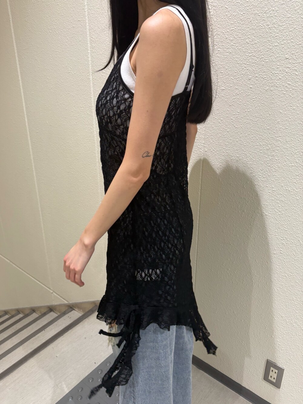 ホワイト系のニット/セーター、ブラック系のワンピース、ブルー系のデニムパンツを着用したレディースの夏コーディネートの7枚目の写真