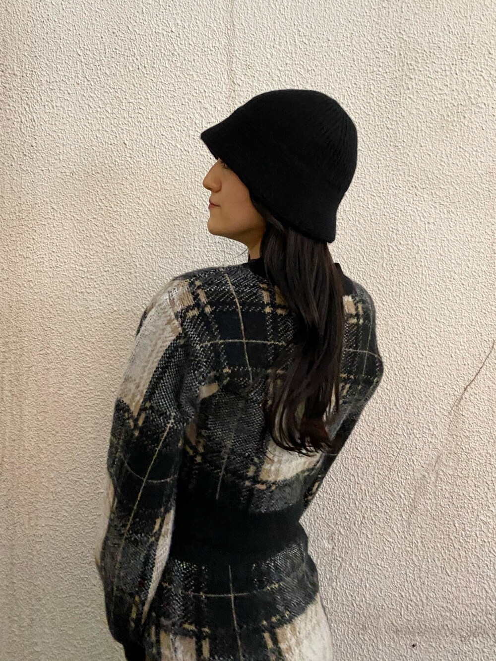 ブラック系のスカート、ブラック系のニット/セーター、ブラック系のブーツを着用したレディースの冬コーディネートの5枚目の写真