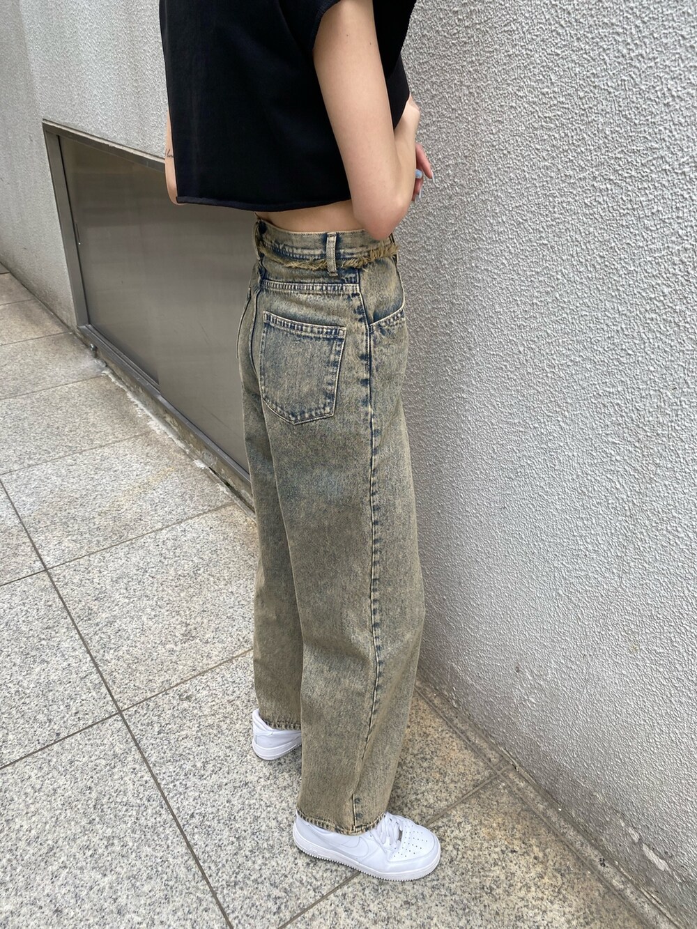 ブラック系のTシャツ/カットソー、ブラック系のハンドバッグ、ベージュ系のデニムパンツを着用したレディースの夏コーディネートの8枚目の写真