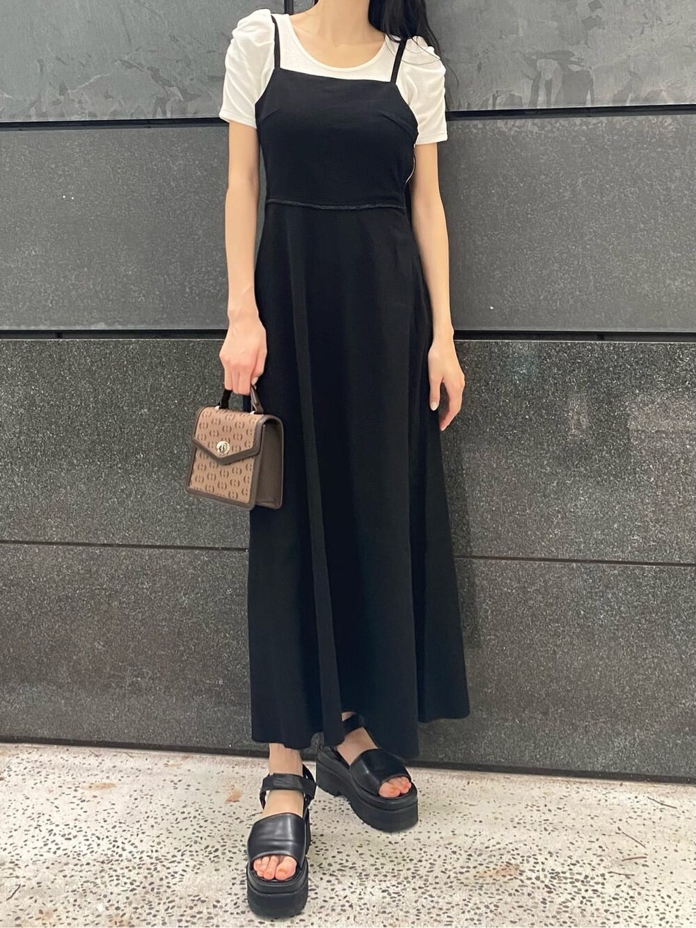 ブラック系のサンダル、ブラック系のワンピース、その他のハンドバッグを着用したレディースの夏コーディネートの2枚目の写真