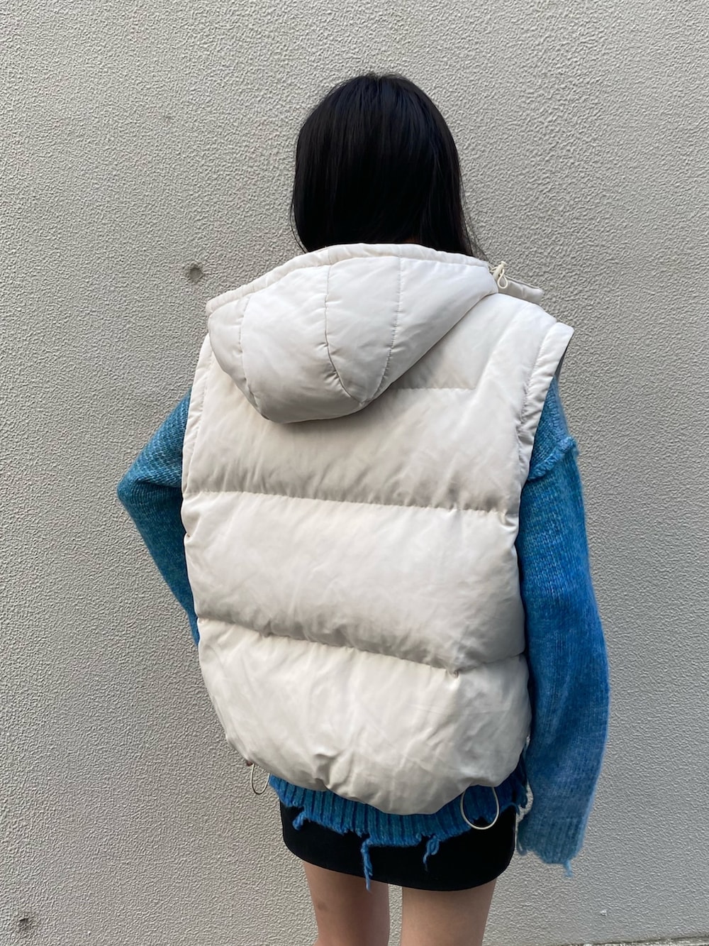 ブルー系のニット/セーター、ブラック系のブーツ、ホワイト系のダウンジャケット/コートを着用したレディースの冬コーディネートの9枚目の写真