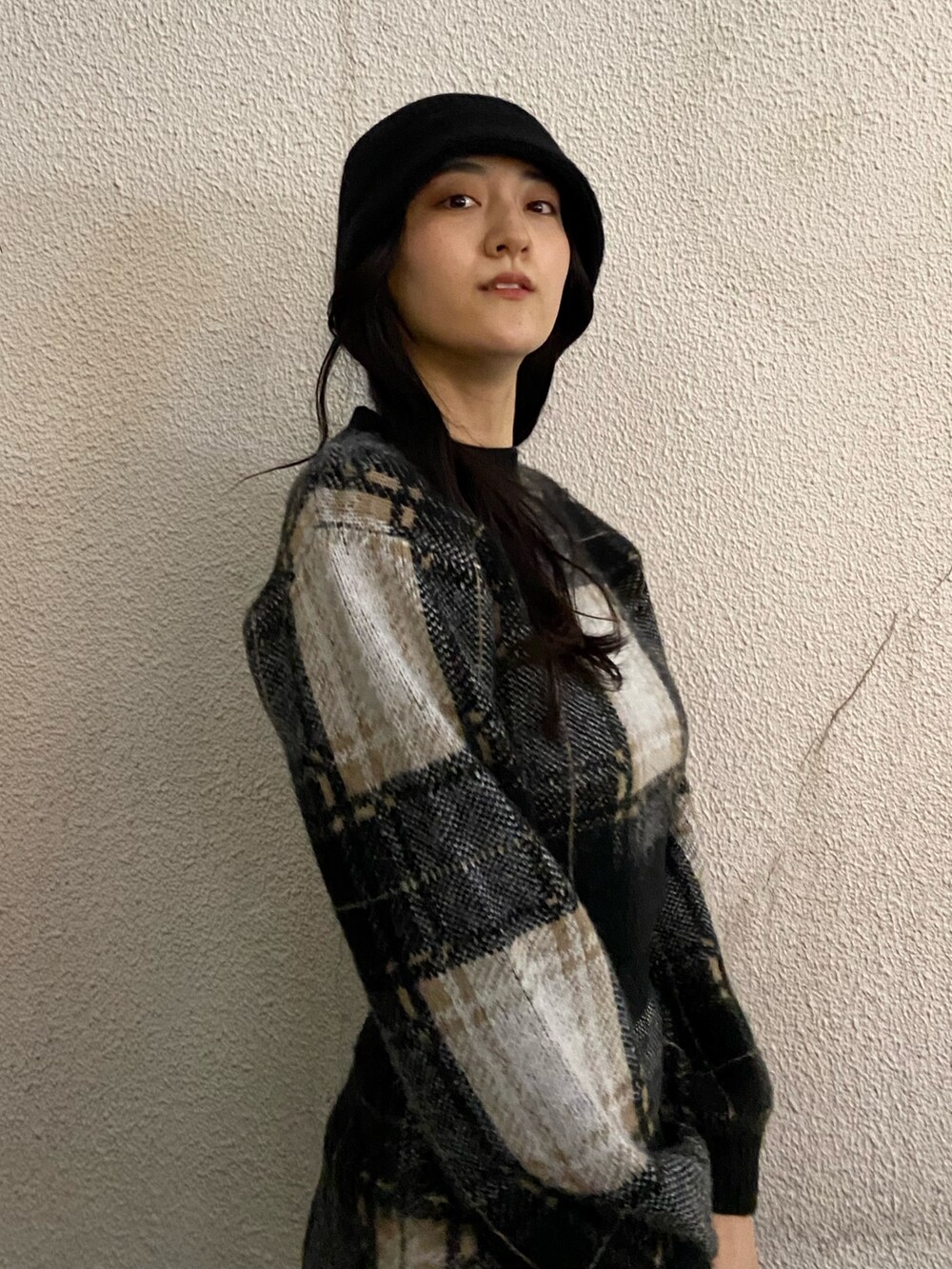 ブラック系のスカート、ブラック系のニット/セーター、ブラック系のブーツを着用したレディースの冬コーディネートの6枚目の写真