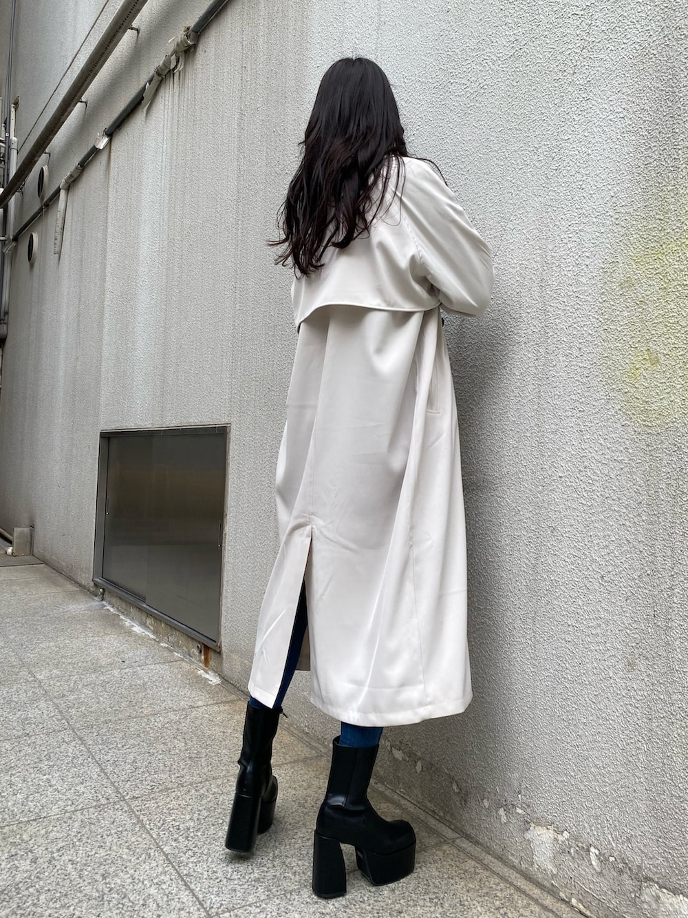 ブラック系のニット/セーター、ブルー系のデニムパンツ、ブラック系のブーツを着用したレディースの冬コーディネートの4枚目の写真