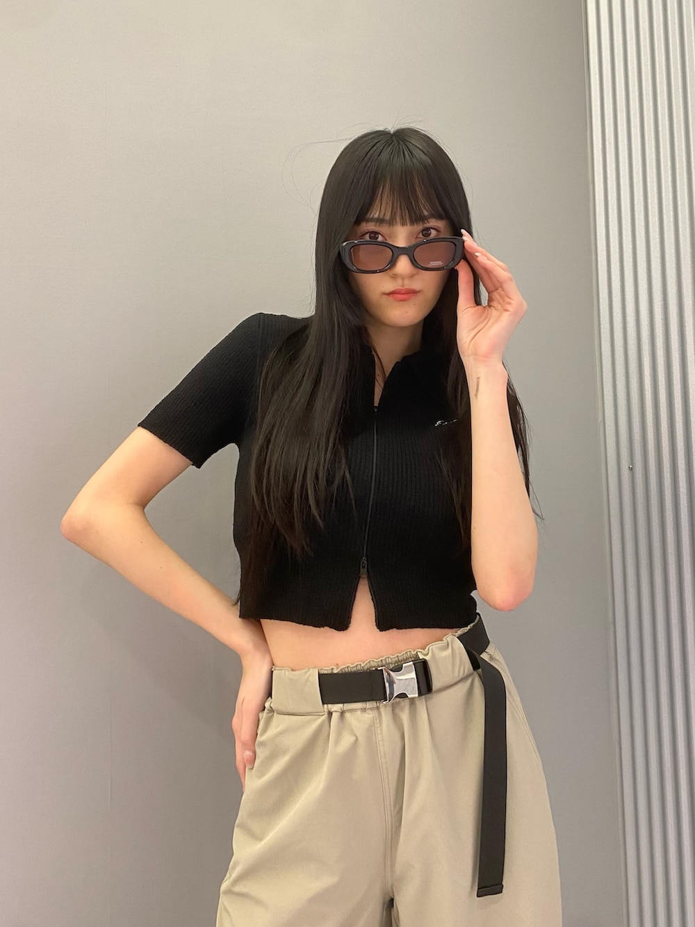 ベージュ系のカーゴパンツ、ブラック系のニット/セーター、ブラック系のブーツを着用したレディースの春コーディネートの5枚目の写真