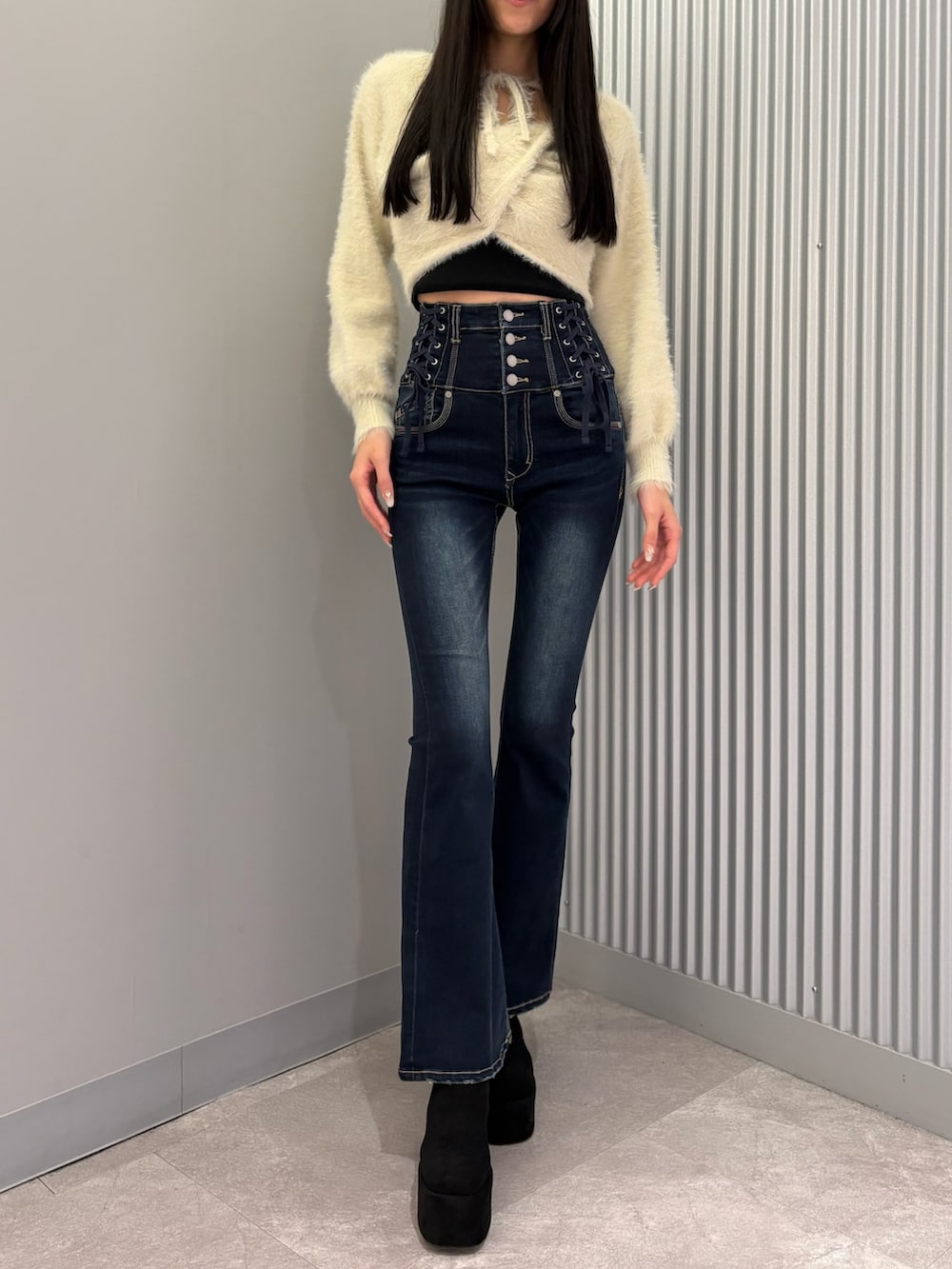 ブルー系のデニムパンツ、ブラック系のキャミソール、ホワイト系のニット/セーターを着用したレディースの秋コーディネートの5枚目の写真