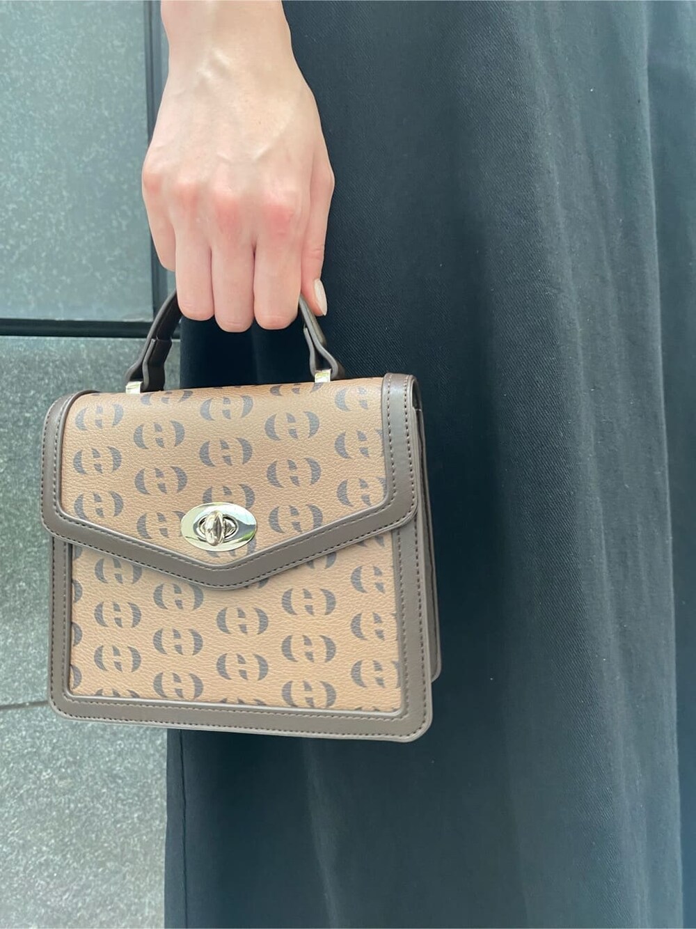 ブラック系のサンダル、ブラック系のワンピース、その他のハンドバッグを着用したレディースの夏コーディネートの7枚目の写真