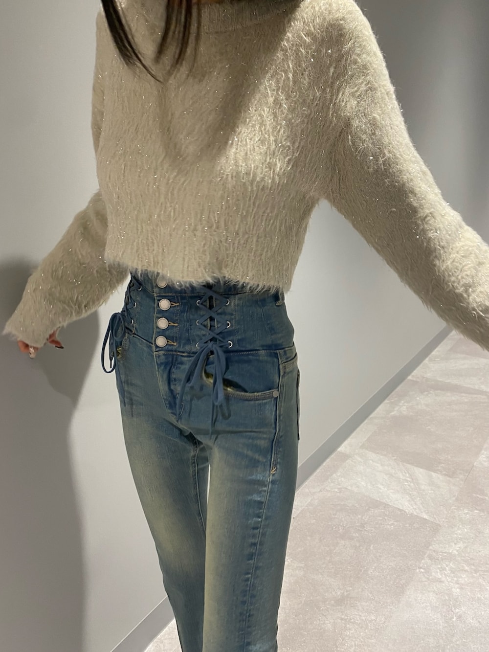 ブラック系のブルゾン、ブルー系のデニムパンツ、ホワイト系のニット/セーターを着用したレディースの冬コーディネートの5枚目の写真