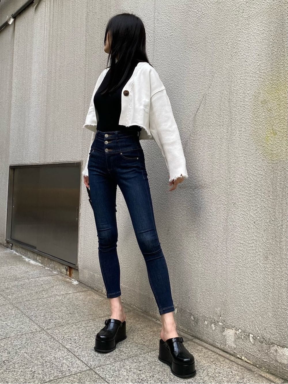 ブルー系のデニムパンツ、ブラック系のスリッポン、ブラック系のTシャツ/カットソーを着用したレディースの秋コーディネートの3枚目の写真