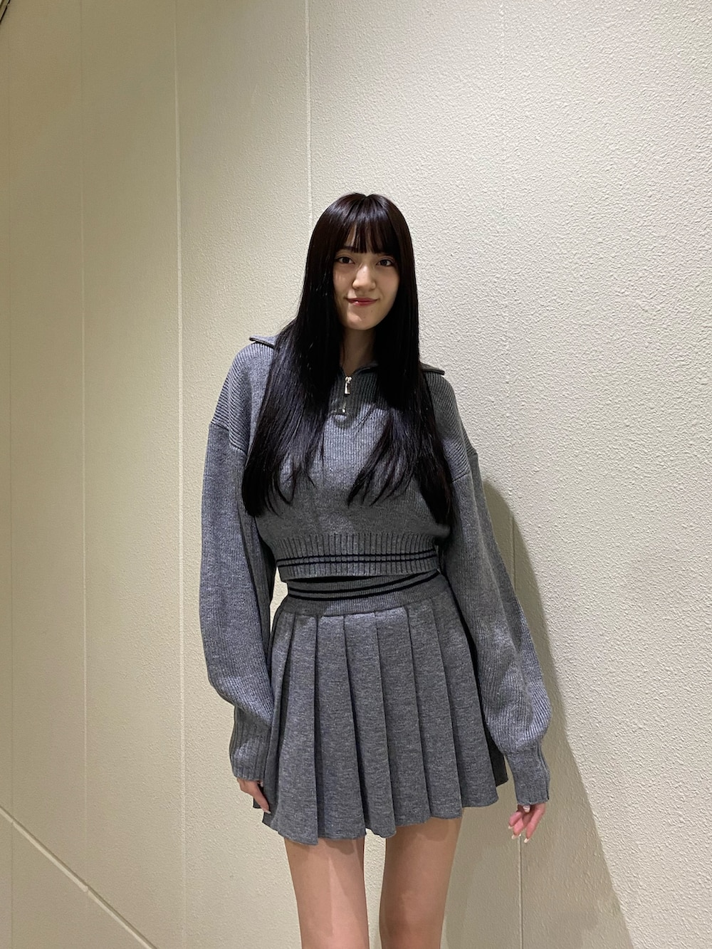 グレー系のニット/セーター、グレー系のスカート、その他のブーツを着用したレディースの秋コーディネートの5枚目の写真