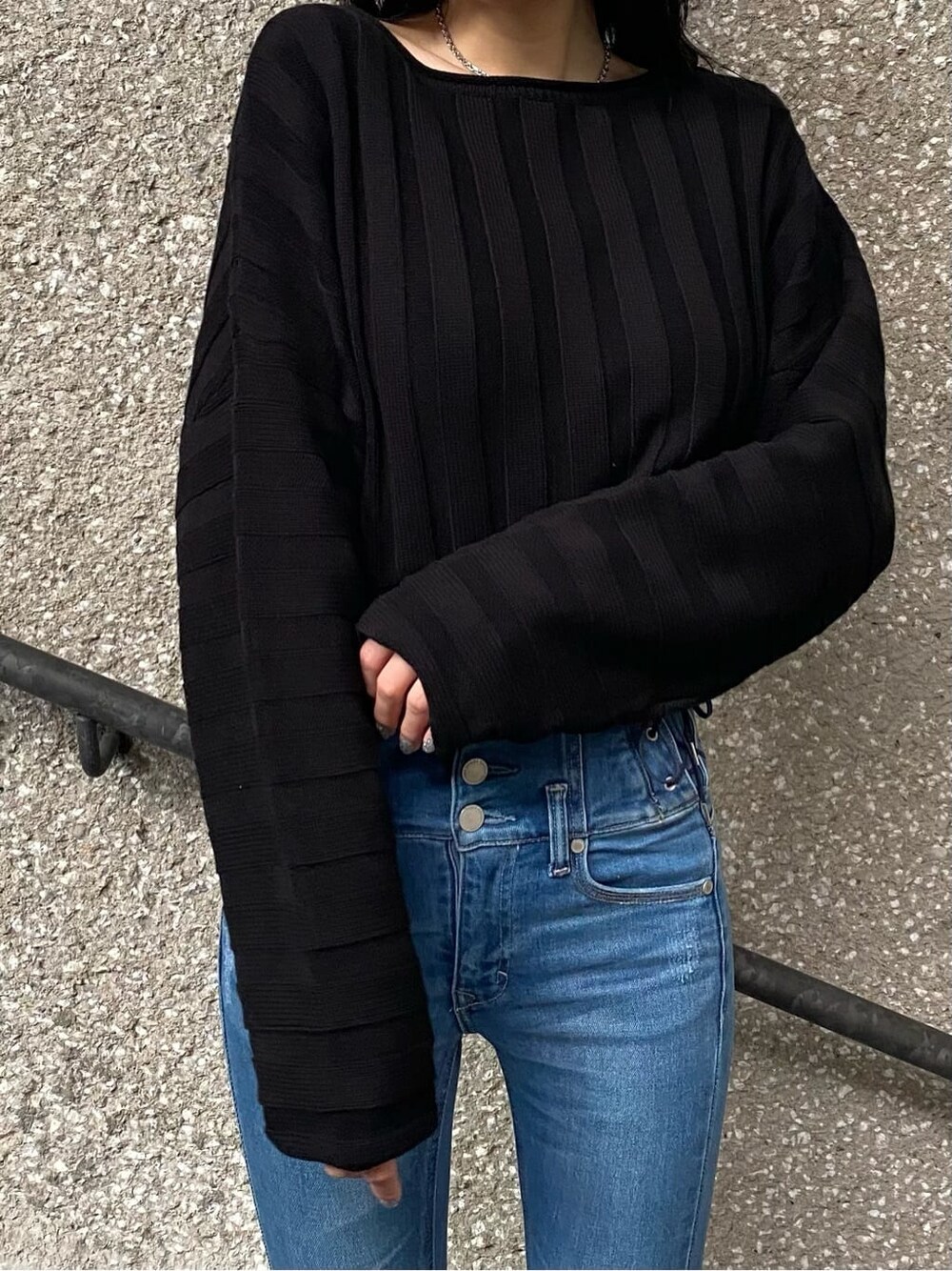 ブルー系のデニムパンツ、ブラック系のニット/セーター、ブラック系のブーツを着用したレディースの冬コーディネートの5枚目の写真