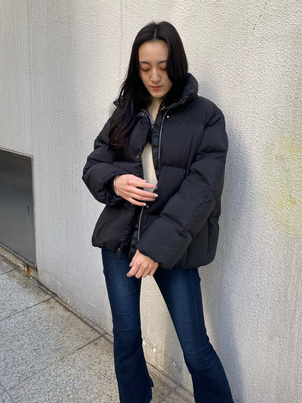 ブルー系のデニムパンツ、ホワイト系のニット/セーター、ブラック系のブーツを着用したレディースの冬コーディネートの6枚目の写真