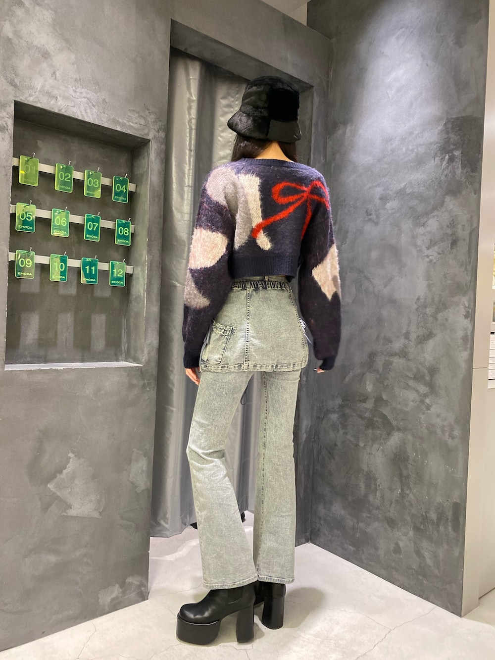 ブルー系のデニムパンツ、ブルー系のニット/セーター、ブラック系のブーツを着用したレディースの秋コーディネートの3枚目の写真