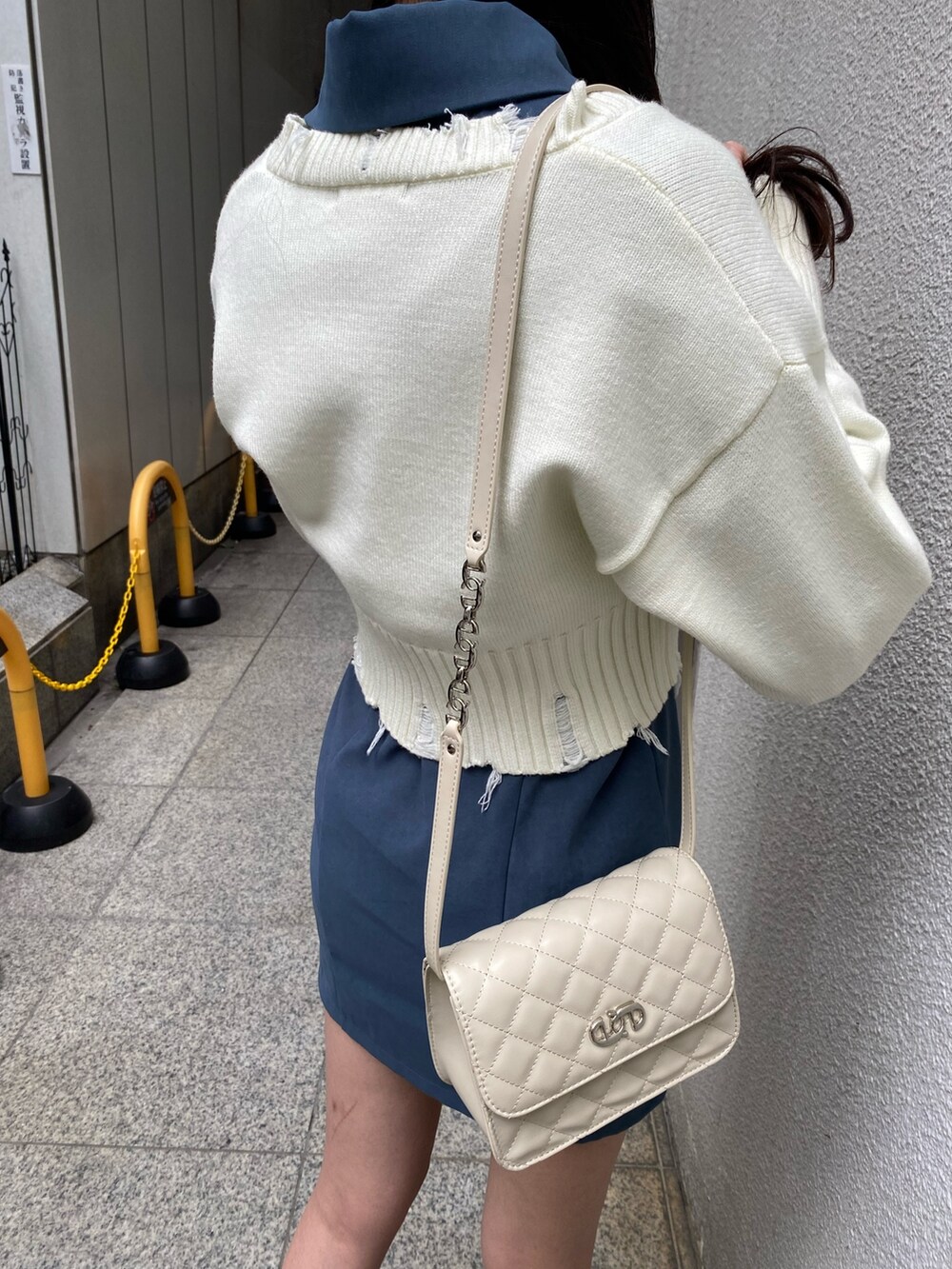 ホワイト系のニット/セーター、ブルー系のワンピース、ホワイト系のショルダーバッグを着用したレディースの冬コーディネートの5枚目の写真