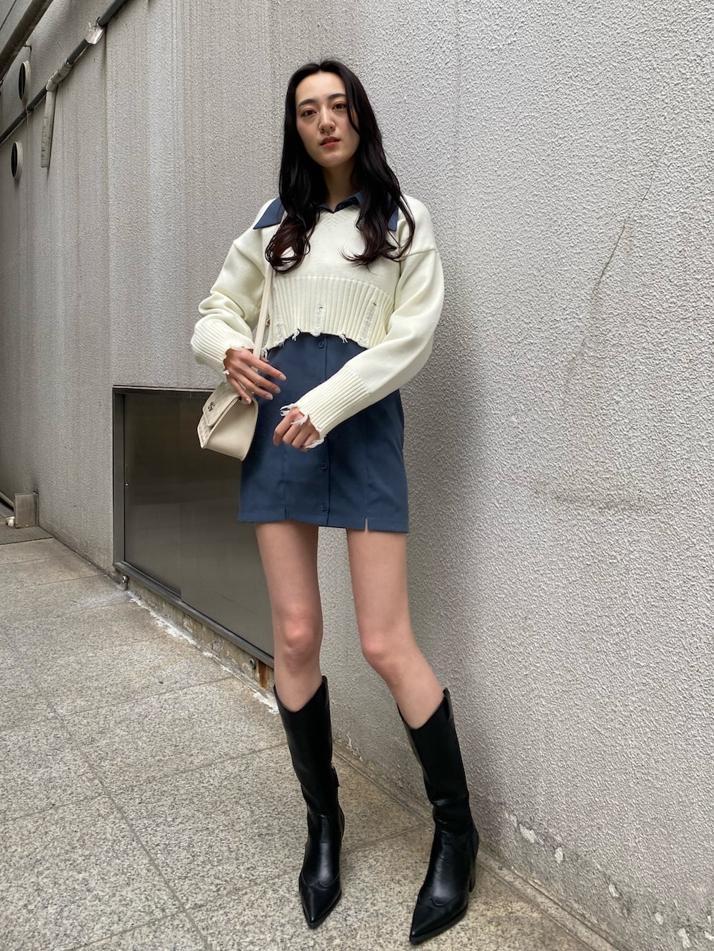 ホワイト系のニット/セーター、ブルー系のワンピース、ホワイト系のショルダーバッグを着用したレディースの冬コーディネートの2枚目の写真