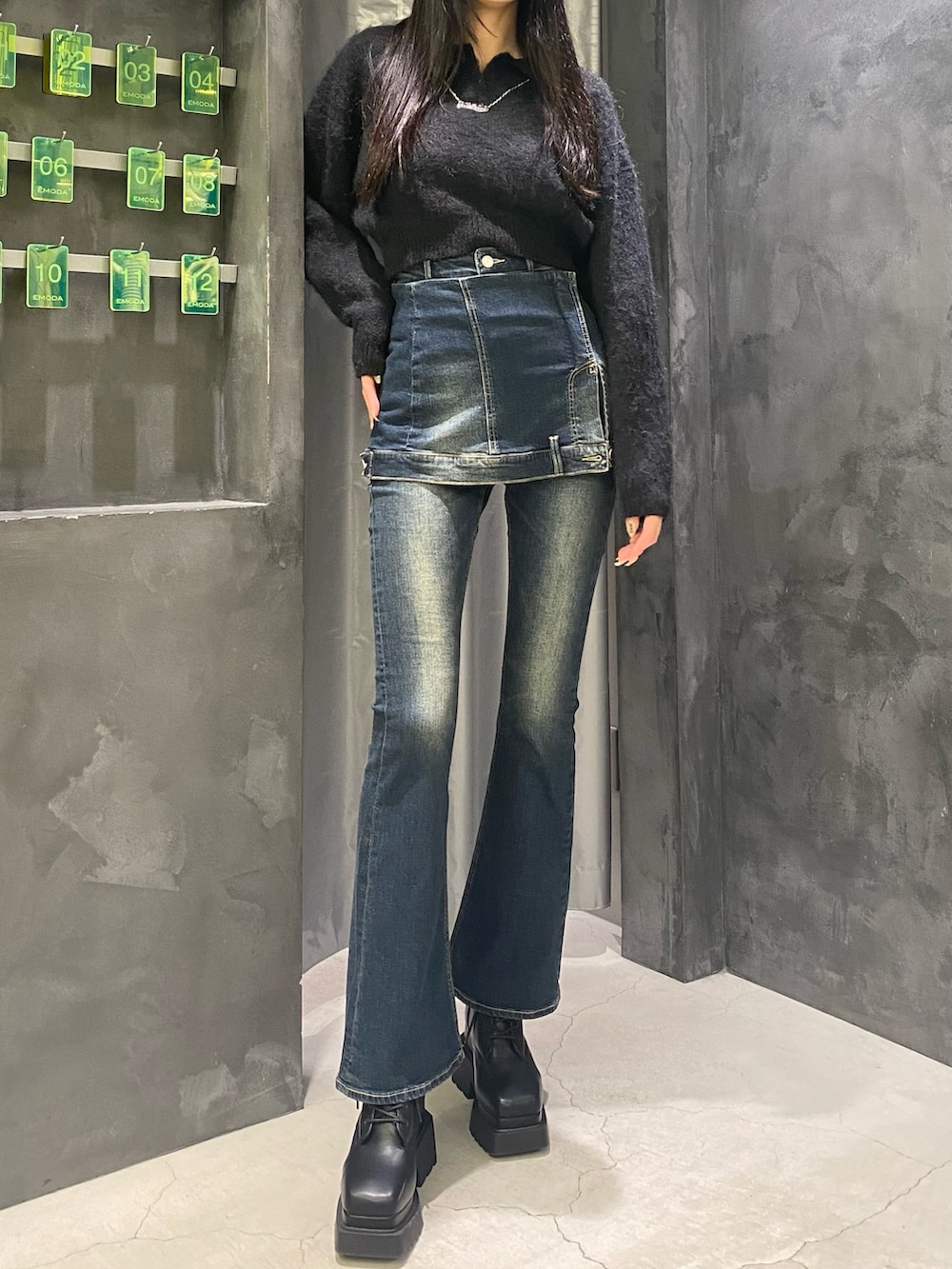 ブルー系のデニムパンツ、ブラック系のニット/セーター、ブラック系のブーツを着用したレディースの秋コーディネートの4枚目の写真