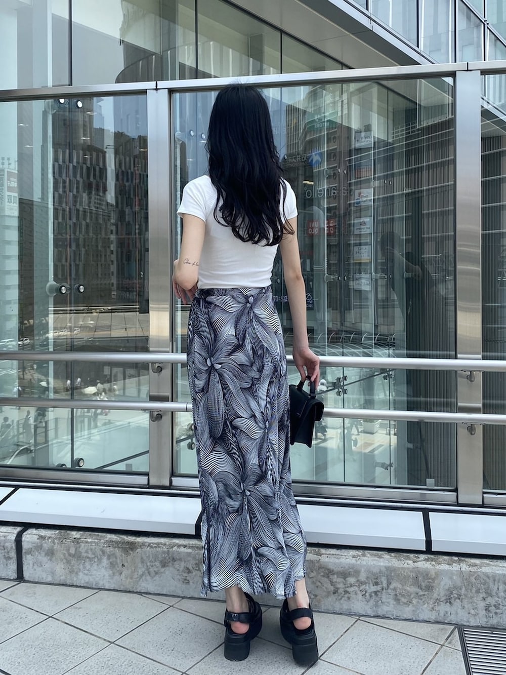 ブラック系のサンダル、ブラック系のハンドバッグ、その他のスカートを着用したレディースの夏コーディネートの4枚目の写真