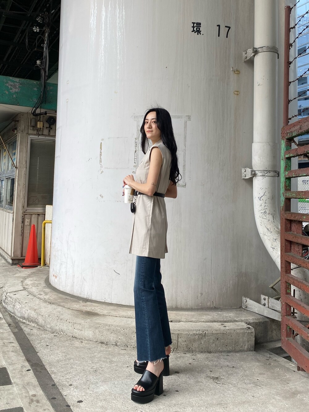 ホワイト系のワンピース、ブルー系のデニムパンツ、ブラック系のサンダルを着用したレディースの春コーディネートの4枚目の写真