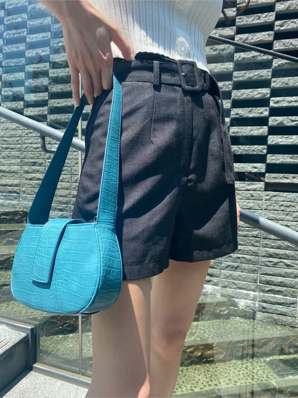 ブルー系のハンドバッグ、ブラック系のその他パンツ、ブラック系のサンダルを着用したレディースの夏コーディネートの4枚目の写真