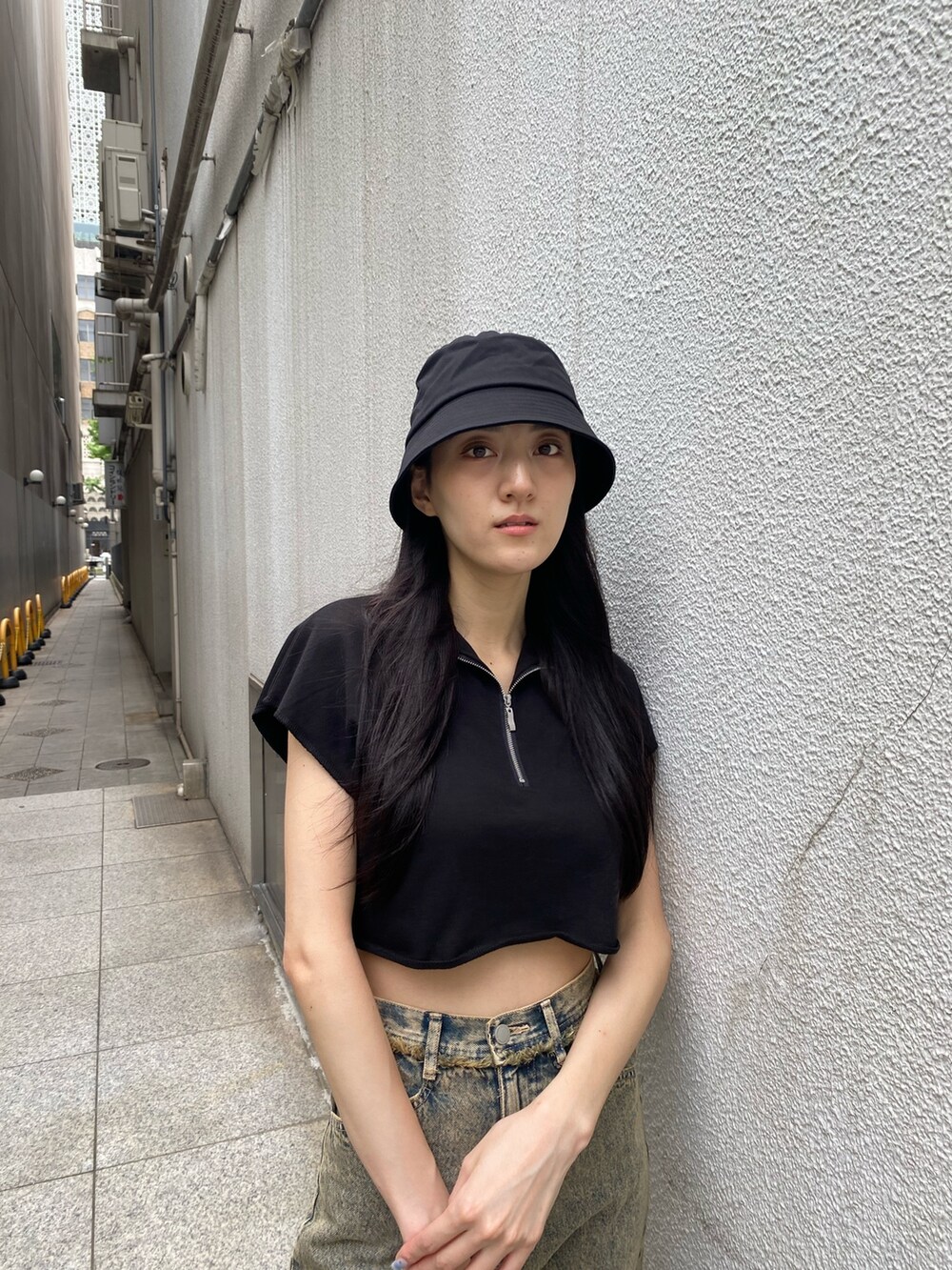 ブラック系のTシャツ/カットソー、ブラック系のハンドバッグ、ベージュ系のデニムパンツを着用したレディースの夏コーディネートの6枚目の写真