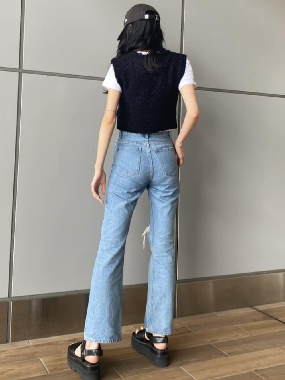 ブラック系のベスト、ブルー系のデニムパンツ、ホワイト系のTシャツ/カットソーを着用したレディースの夏コーディネートの2枚目の写真