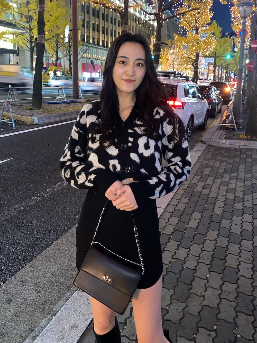 ブラック系のスカート、ブラック系のカーディガン/ボレロ、ブラック系のブーツを着用したレディースの冬コーディネートの4枚目の写真