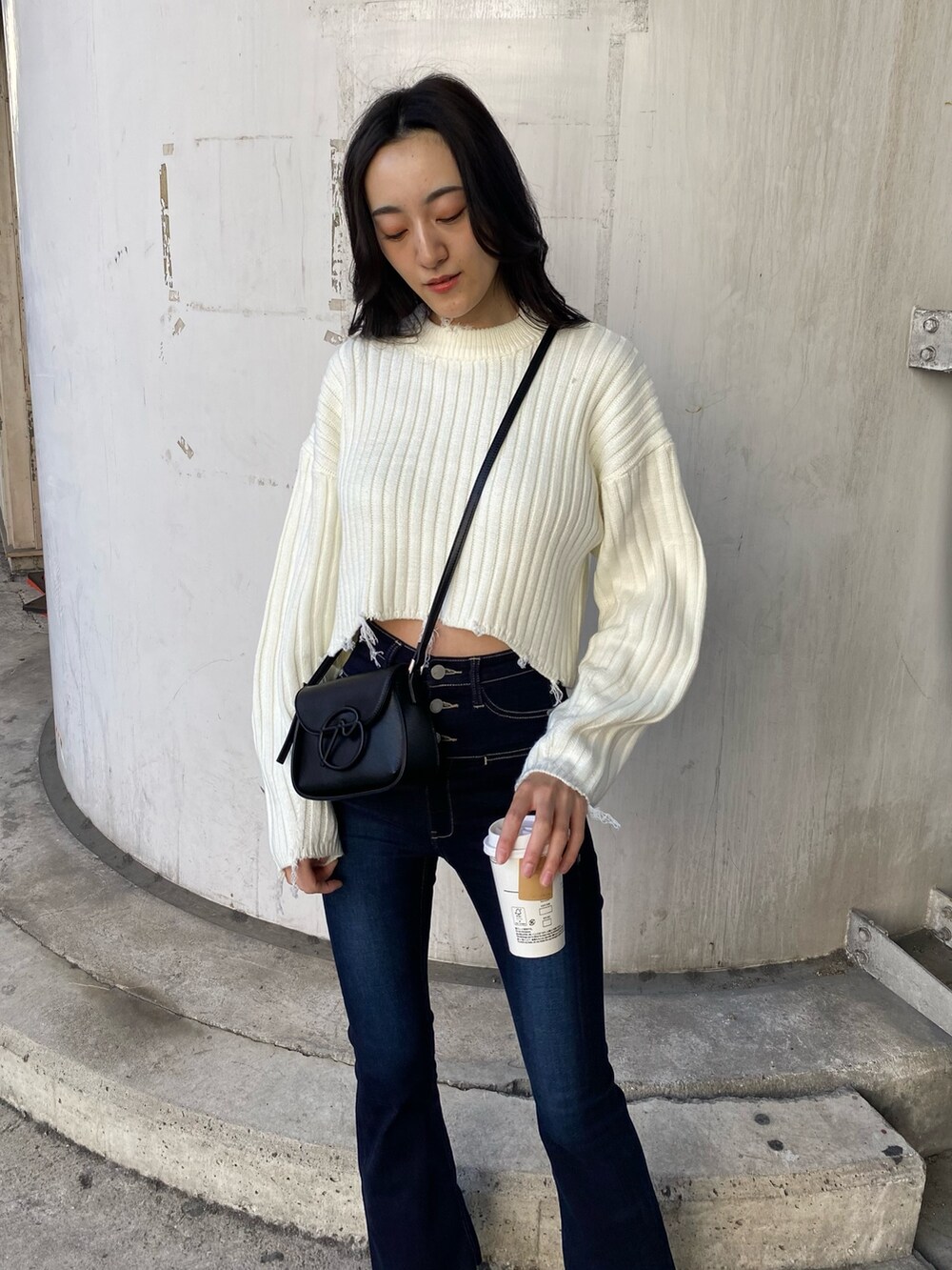 ブルー系のデニムパンツ、ブラック系のムートンコート、ホワイト系のニット/セーターを着用したレディースの秋コーディネートの9枚目の写真