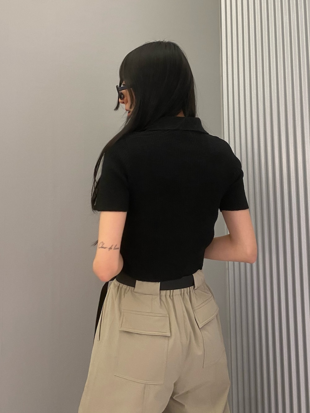 ベージュ系のカーゴパンツ、ブラック系のニット/セーター、ブラック系のブーツを着用したレディースの春コーディネートの7枚目の写真