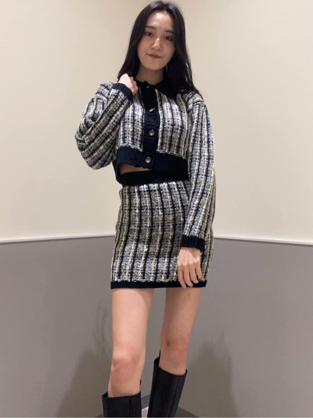 ブラック系のブーツ、ブラック系のスカート、ブラック系のカーディガン/ボレロを着用したレディースの秋コーディネートの4枚目の写真