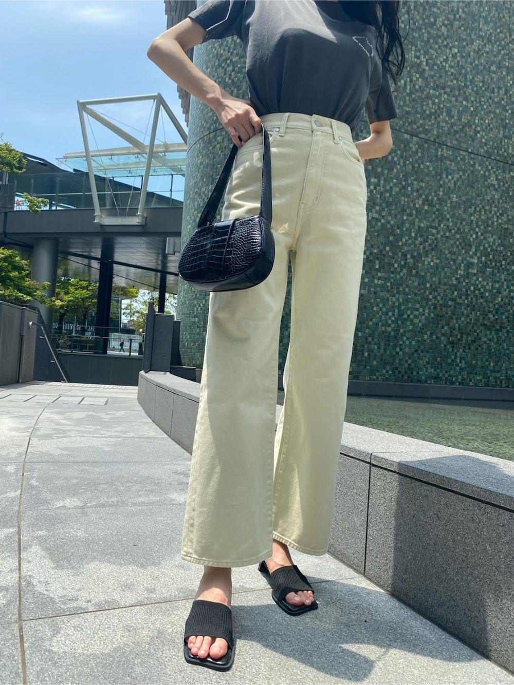 ホワイト系のデニムパンツ、ブラック系のサンダル、ブラック系のハンドバッグを着用したレディースの夏コーディネートの6枚目の写真