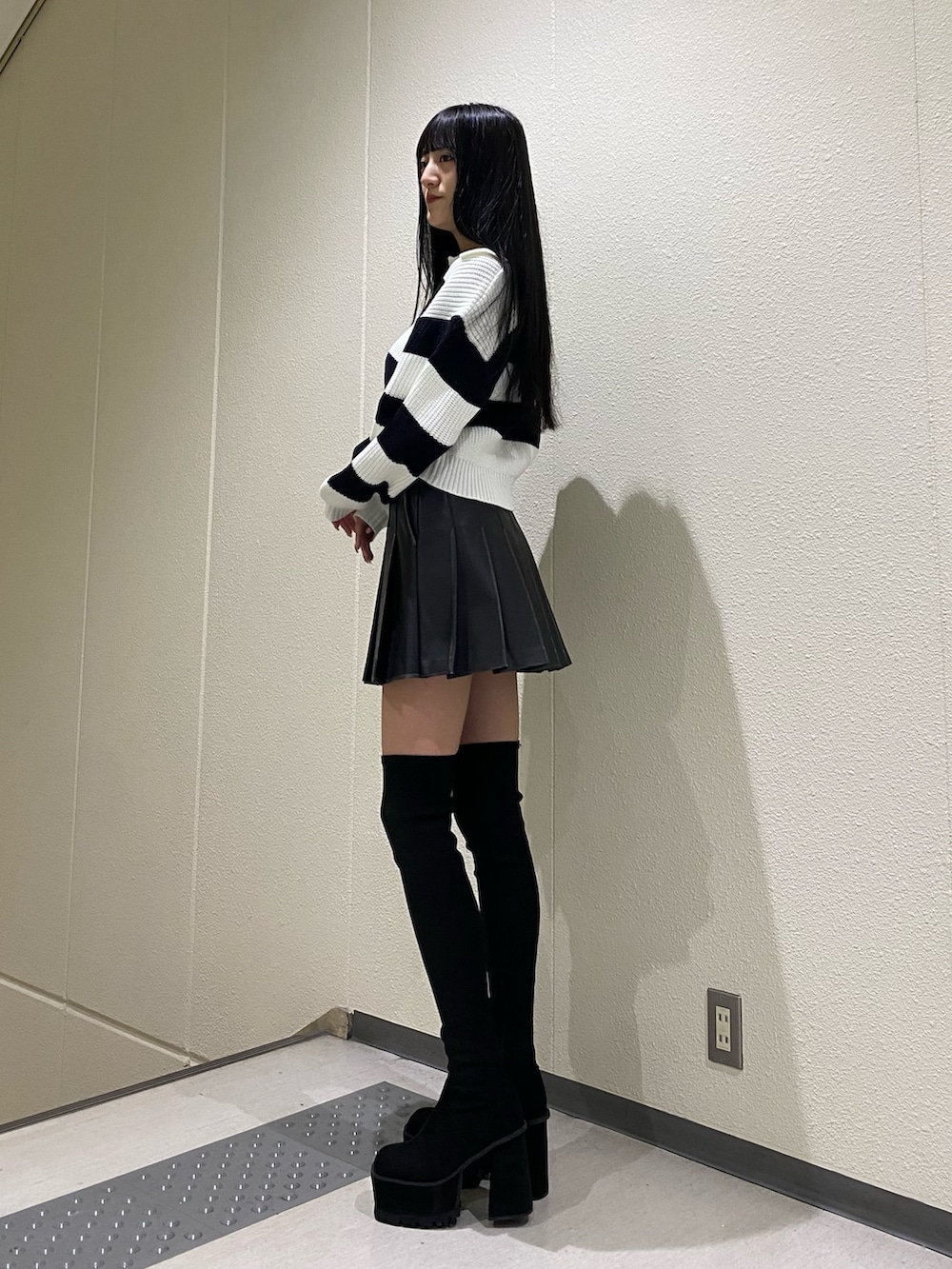 ブラック系のスカート、その他のニット/セーター、ブラック系のブーツを着用したレディースの冬コーディネートの3枚目の写真