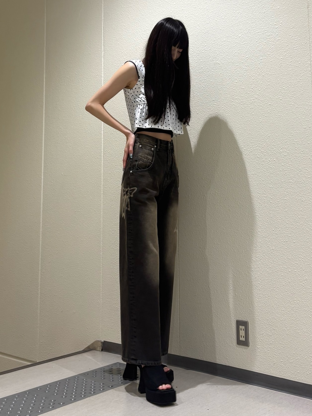 ブラック系のデニムパンツ、ホワイト系のタンクトップ、ブラック系のTシャツ/カットソーを着用したレディースの夏コーディネートの5枚目の写真