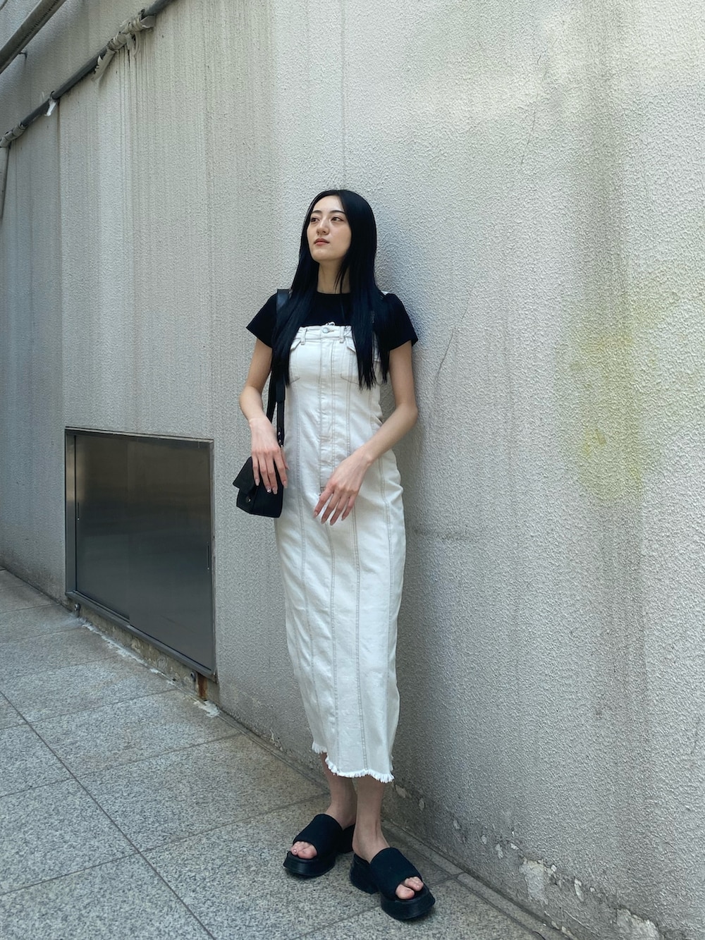 ブラック系のTシャツ/カットソー、ホワイト系のワンピース、ブラック系のショルダーバッグを着用したレディースの夏コーディネートの2枚目の写真