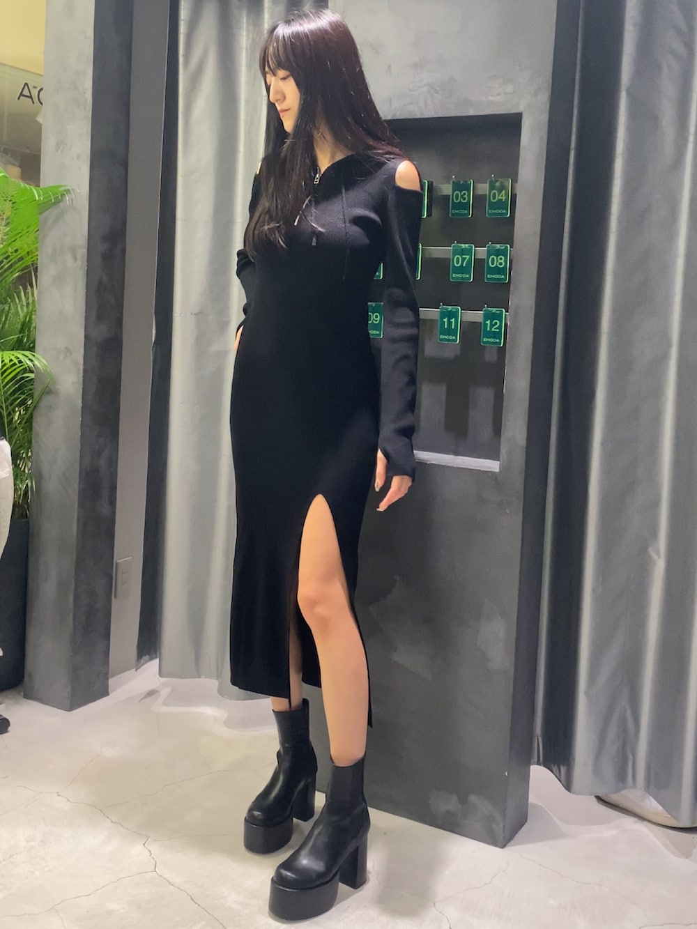 ブラック系のワンピース、ブラック系のブーツを着用したレディースの秋コーディネートの7枚目の写真