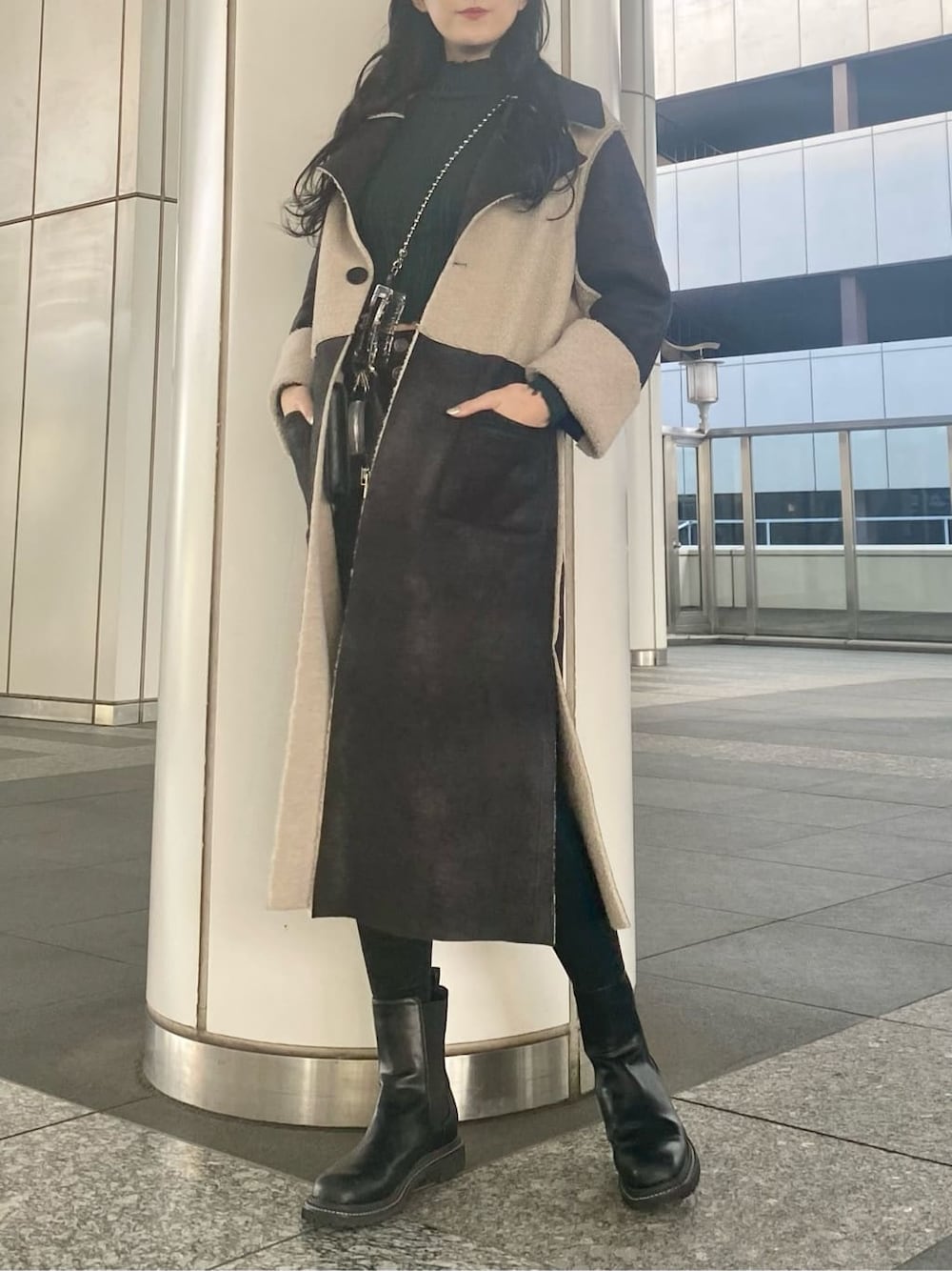 ブラック系のデニムパンツ、ブラック系のムートンコート、ブラック系のショルダーバッグを着用したレディースの冬コーディネートの3枚目の写真