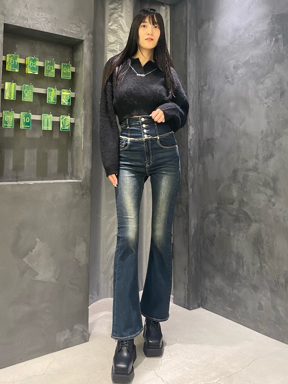 ブルー系のデニムパンツ、ブラック系のニット/セーター、ブラック系のブーツを着用したレディースの秋コーディネートの5枚目の写真