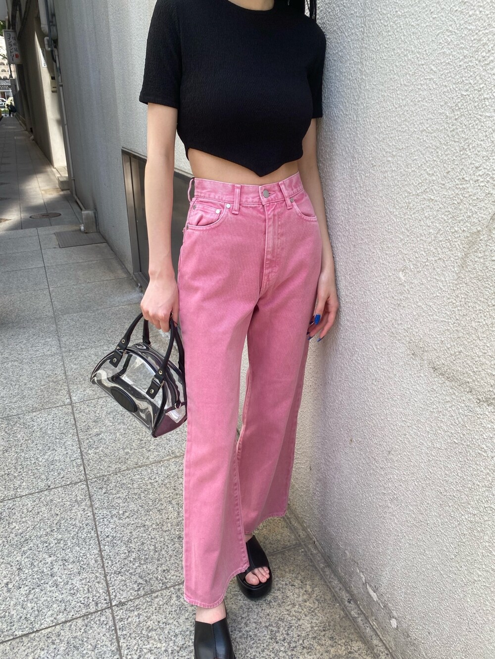 ピンク系のデニムパンツ、ブラック系のTシャツ/カットソー、その他のハンドバッグを着用したレディースの春コーディネートの6枚目の写真