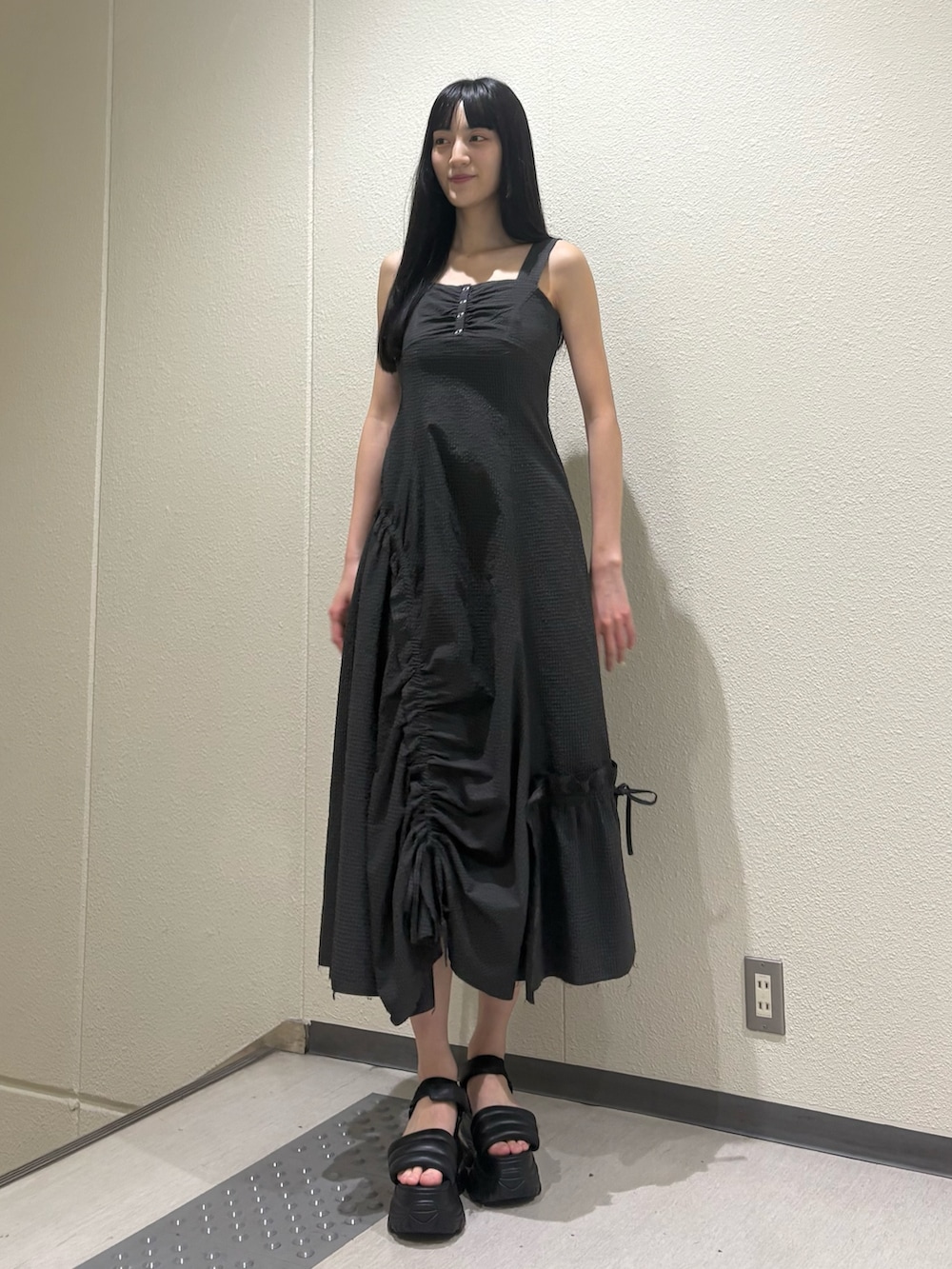 グレー系のワンピース、ブラック系のサンダルを着用したレディースの夏コーディネートの2枚目の写真