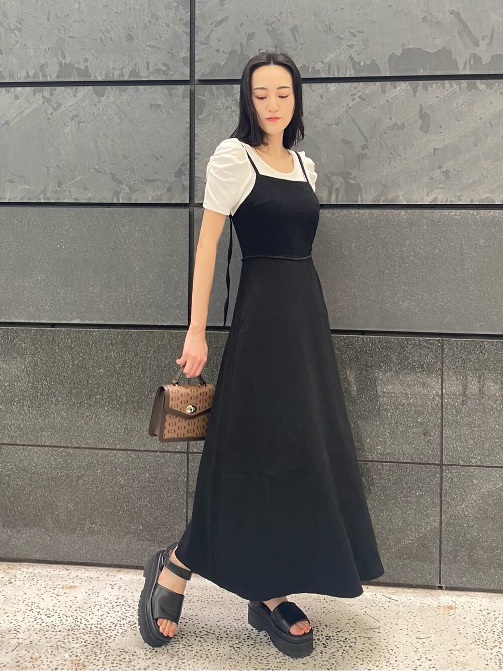 ブラック系のサンダル、ブラック系のワンピース、その他のハンドバッグを着用したレディースの夏コーディネートの4枚目の写真