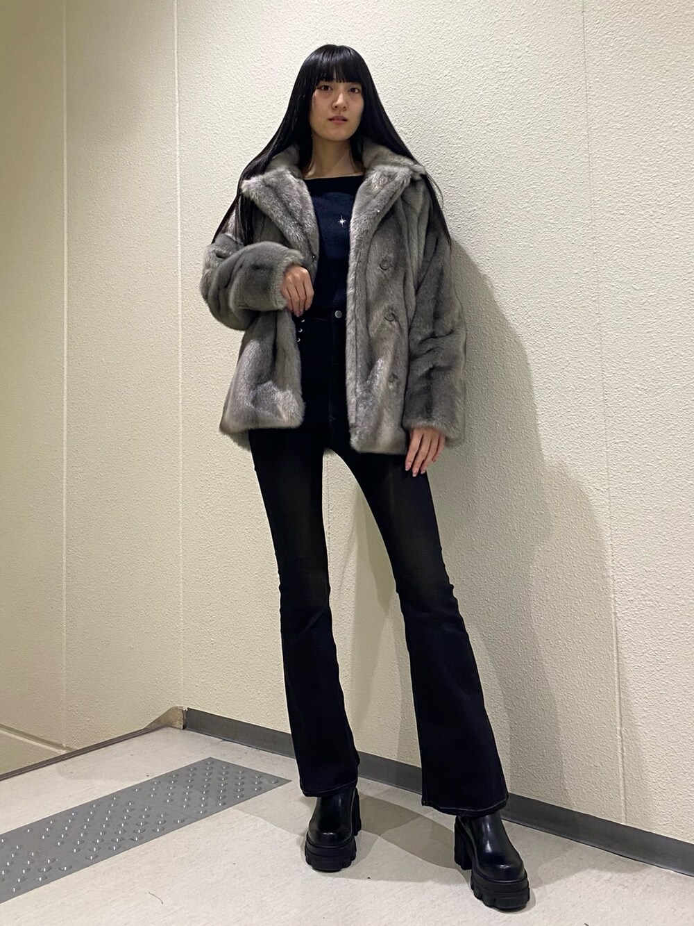 ブラック系のデニムパンツ、ブラック系のブーツ、ブラック系のニット/セーターを着用したレディースの冬コーディネートの5枚目の写真