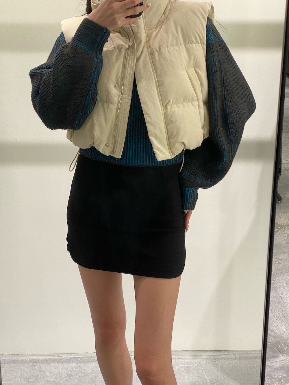 ブラック系のスカート、ブラック系のブーツ、ブルー系のニット/セーターを着用したレディースの秋コーディネートの5枚目の写真