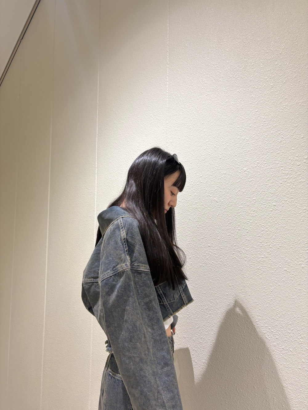 ブルー系のスカート、ブルー系のデニムジャケット、ホワイト系のキャミソールを着用したレディースの夏コーディネートの8枚目の写真